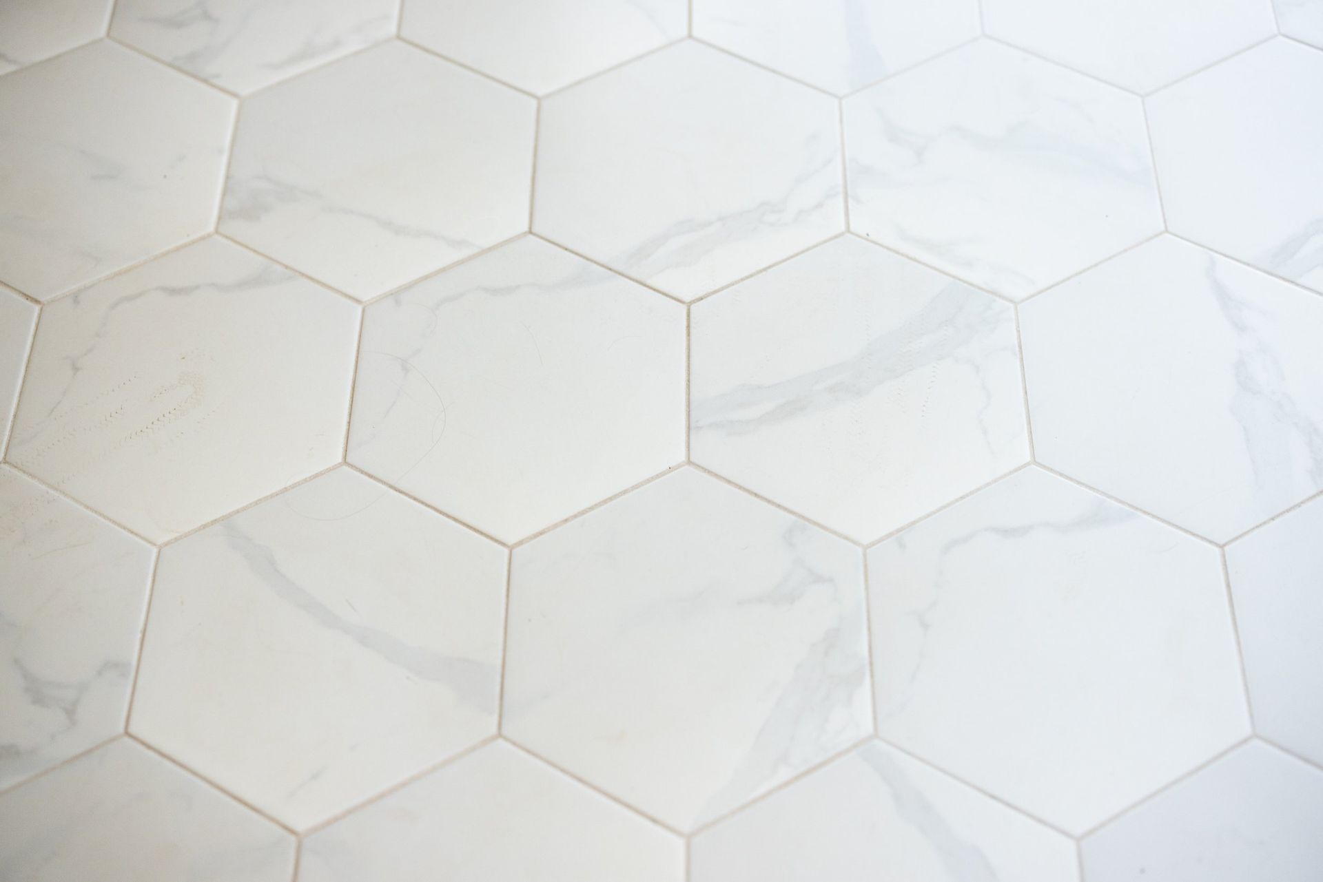 White hexagonal tiled surface with subtle gray veining