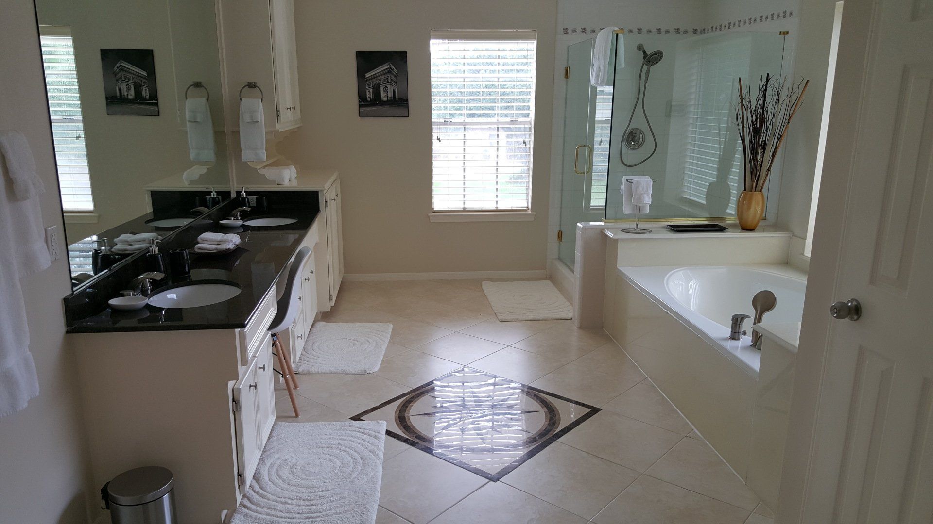 A bathroom with two sinks , a tub and a shower.