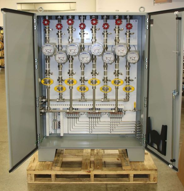 A box with a bunch of gauges on it is sitting on a wooden pallet