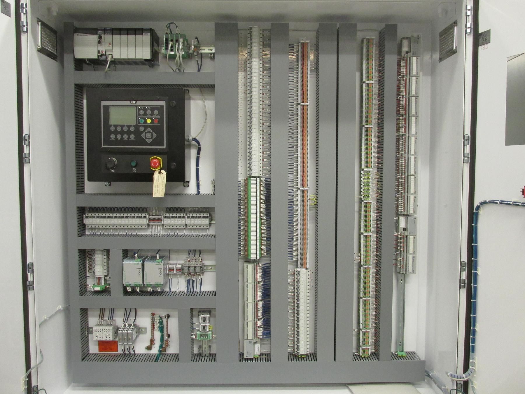 A large electrical control panel with a lot of wires coming out of it