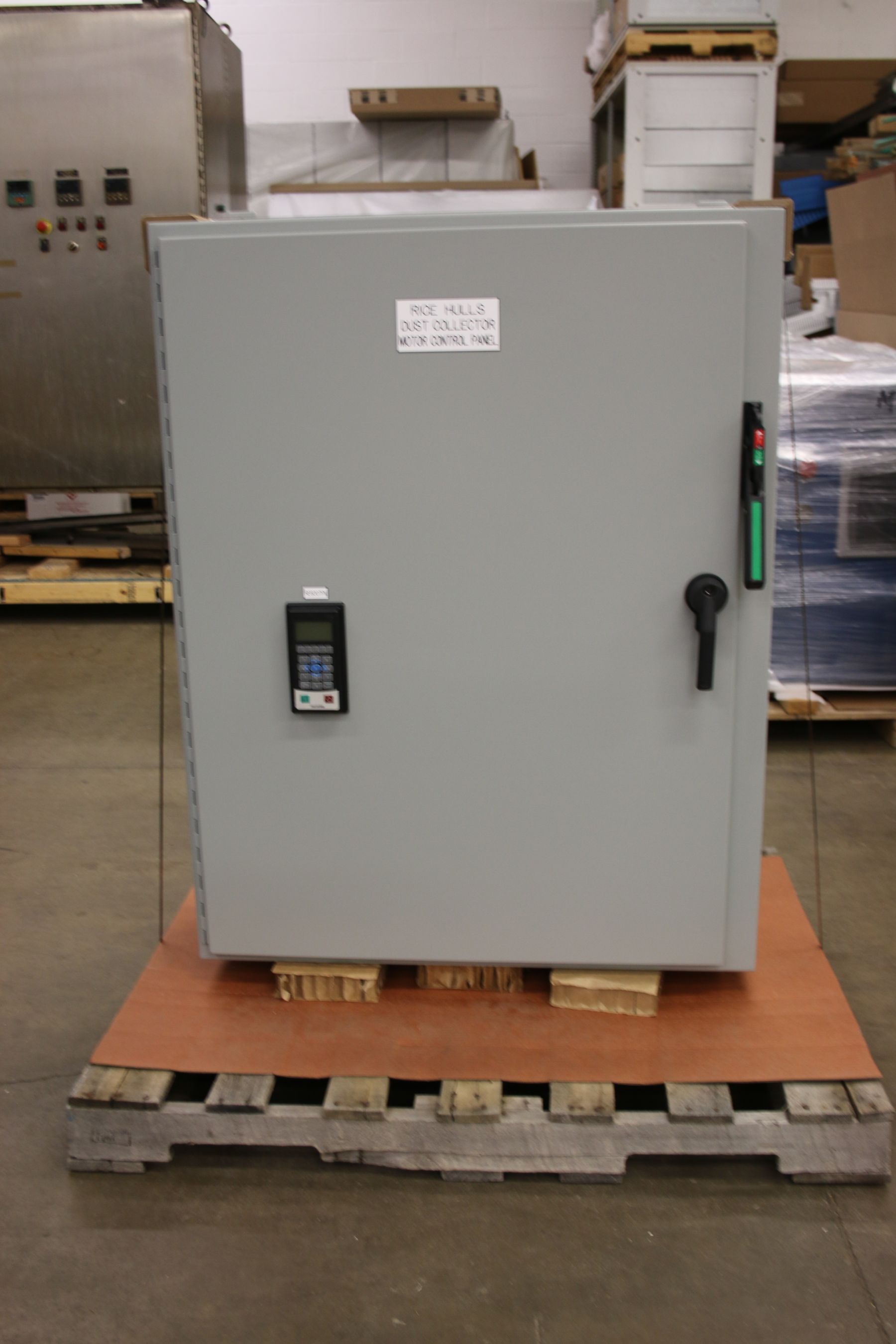 A large electrical box is sitting on a wooden pallet