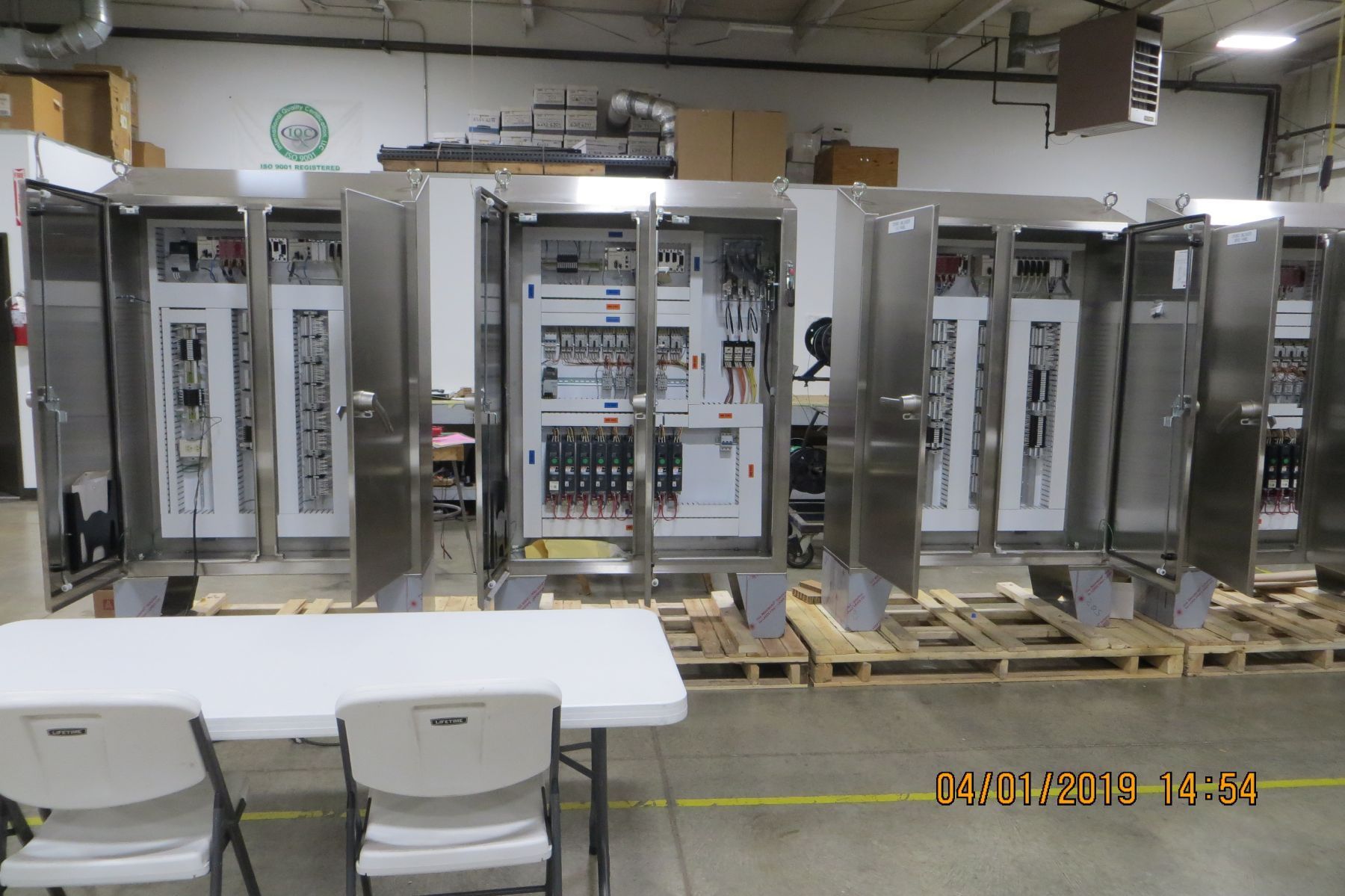 A table and chairs in front of a row of electrical boxes