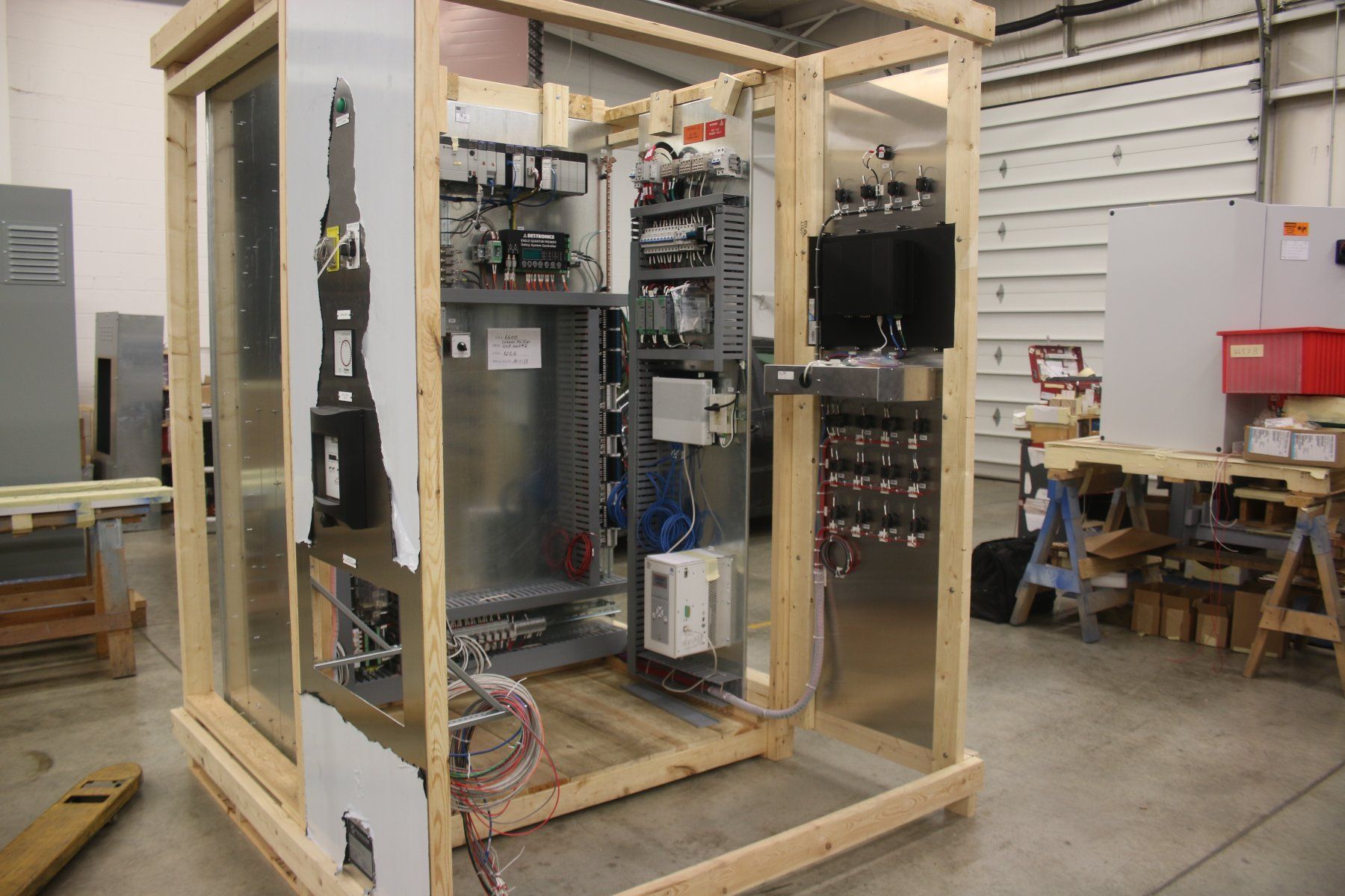 A wooden box filled with electrical equipment in a warehouse.