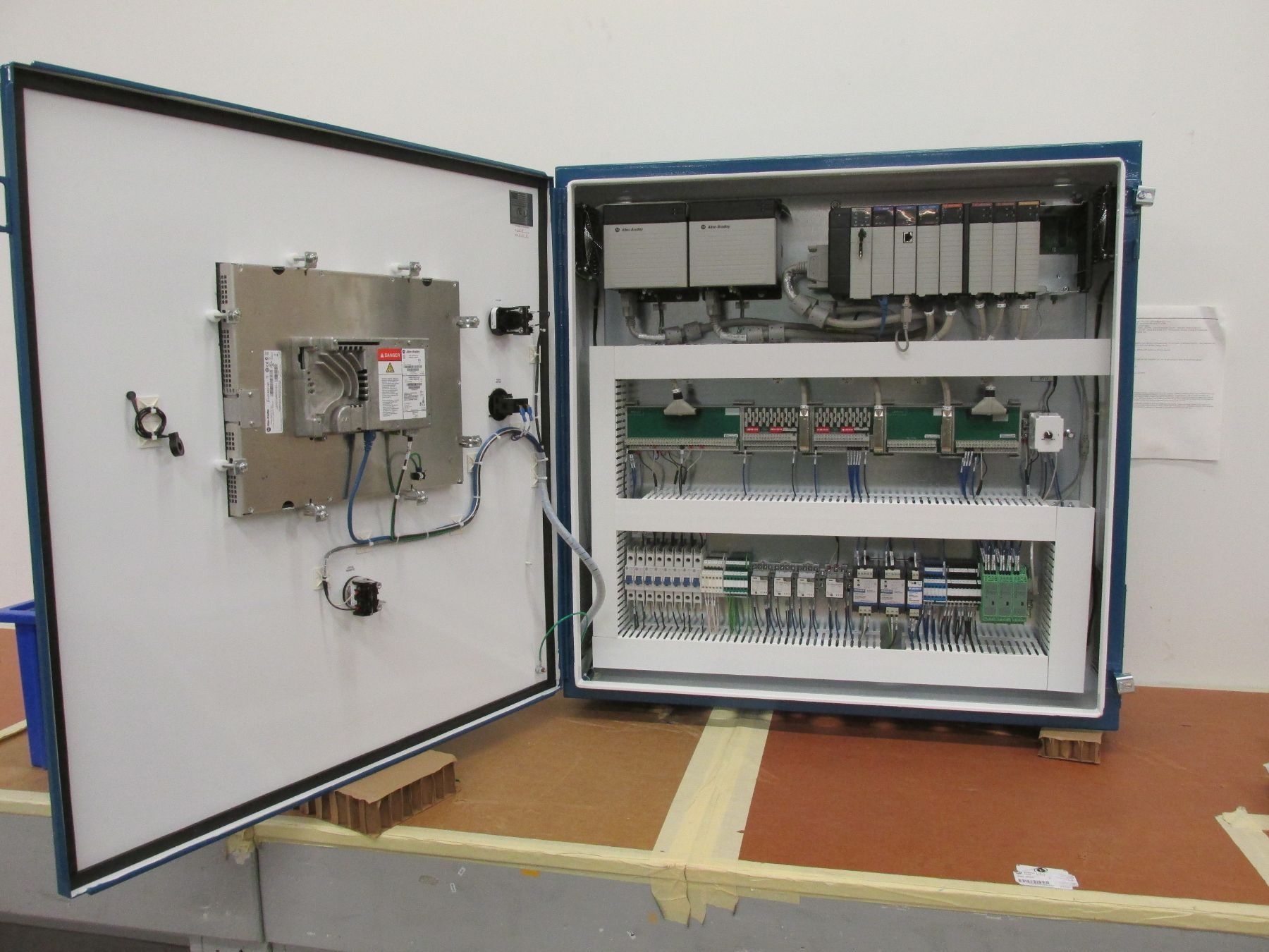 A electrical box with the door open is sitting on a table.