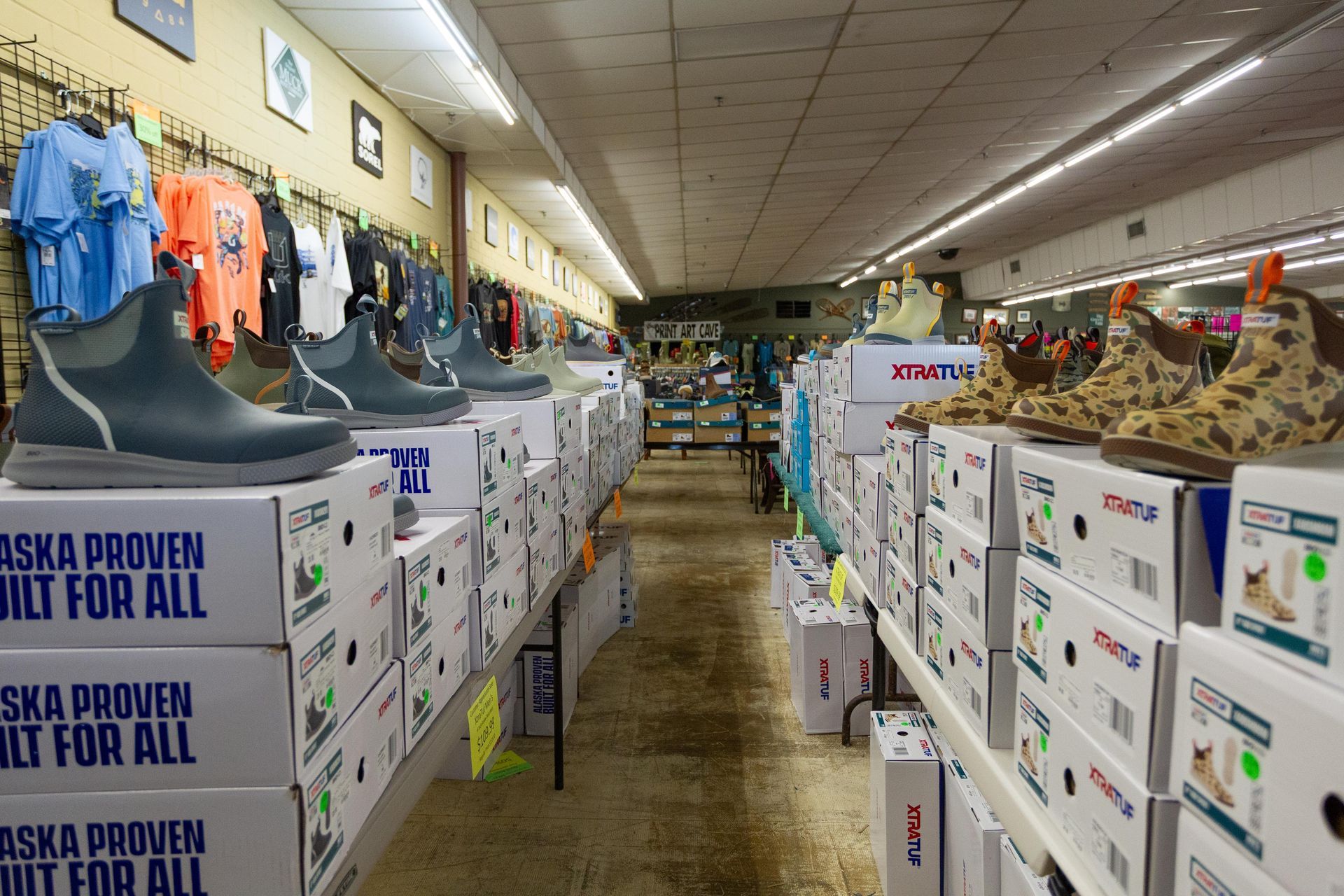 Interior of a store selling waterproof boots, with boxes stacked on shelves and clothing on the wall.