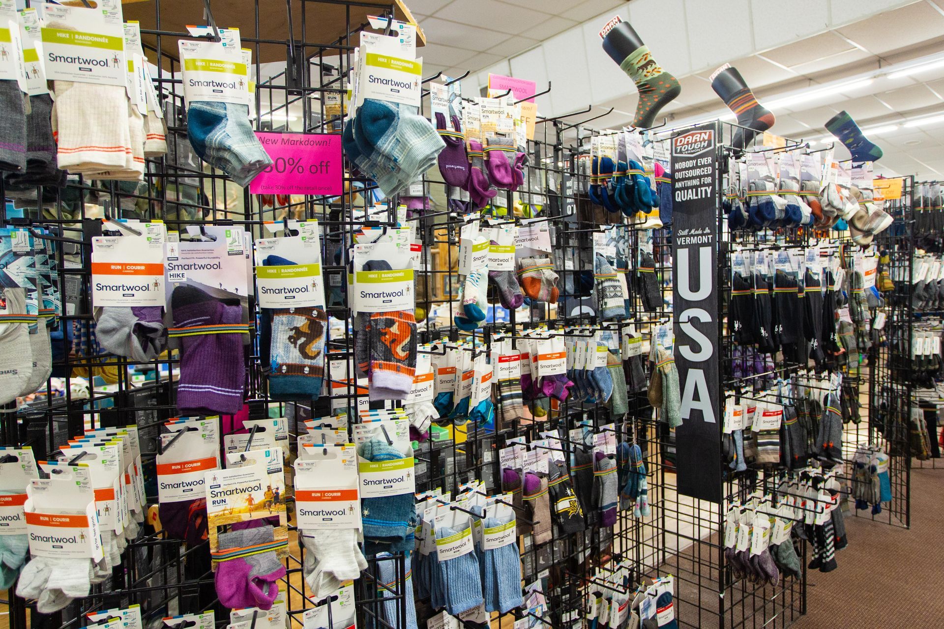 A display of colorful socks hanging on wire racks in a store, with 