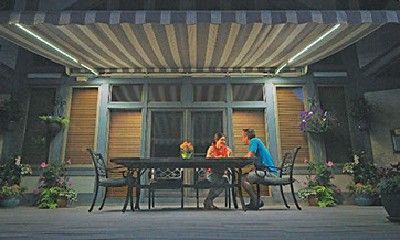 A man and a woman are sitting at a table under an awning.