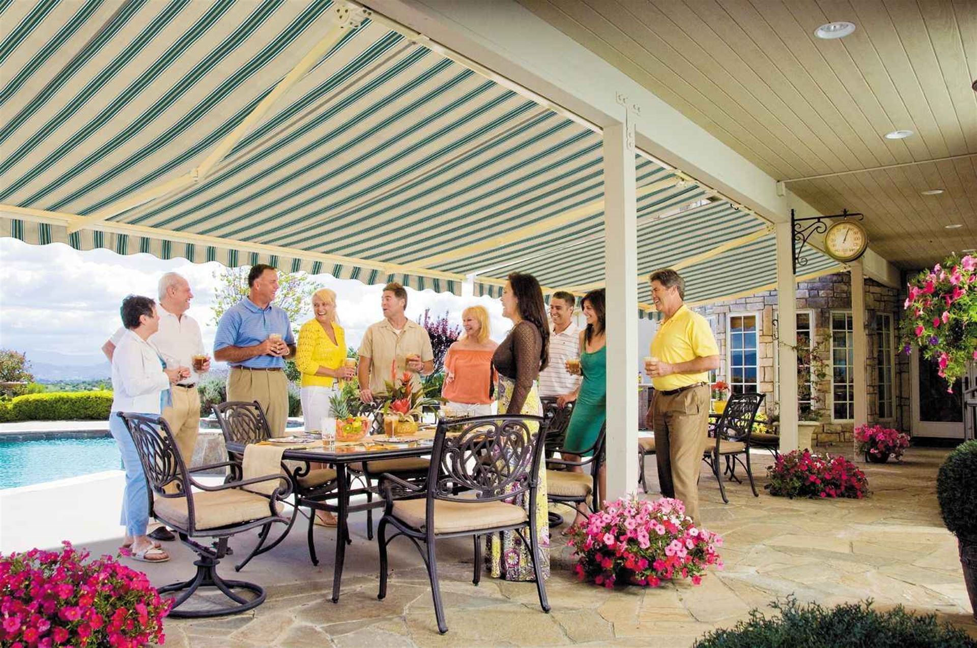 A group of people are standing around a table under an awning.