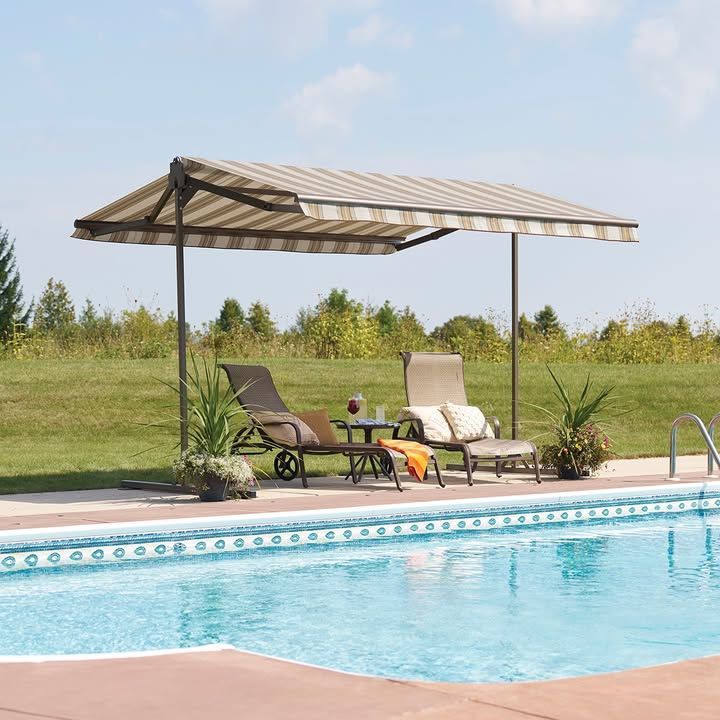 A swimming pool with a striped awning over it