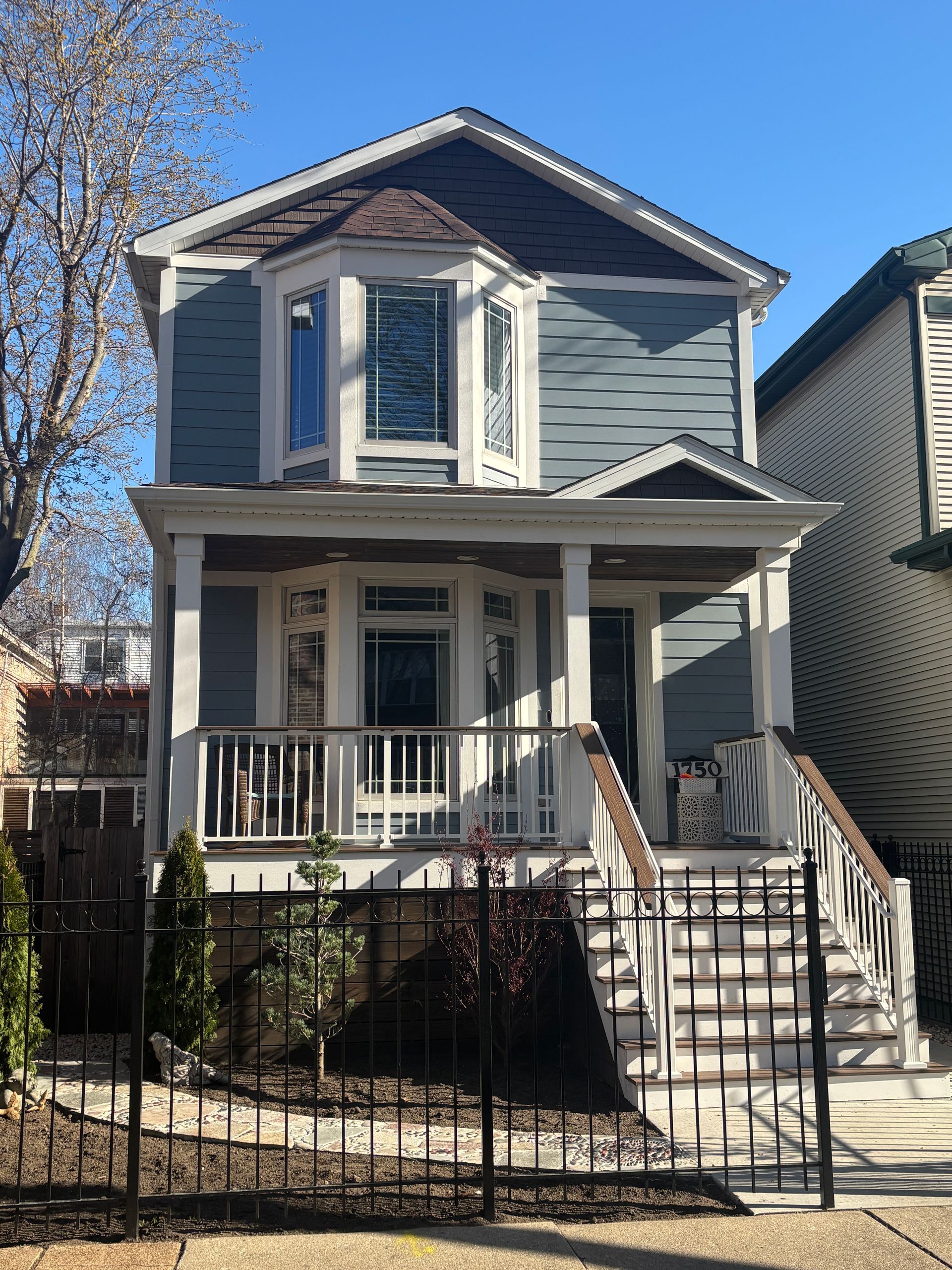 Blue house with a black metal fence