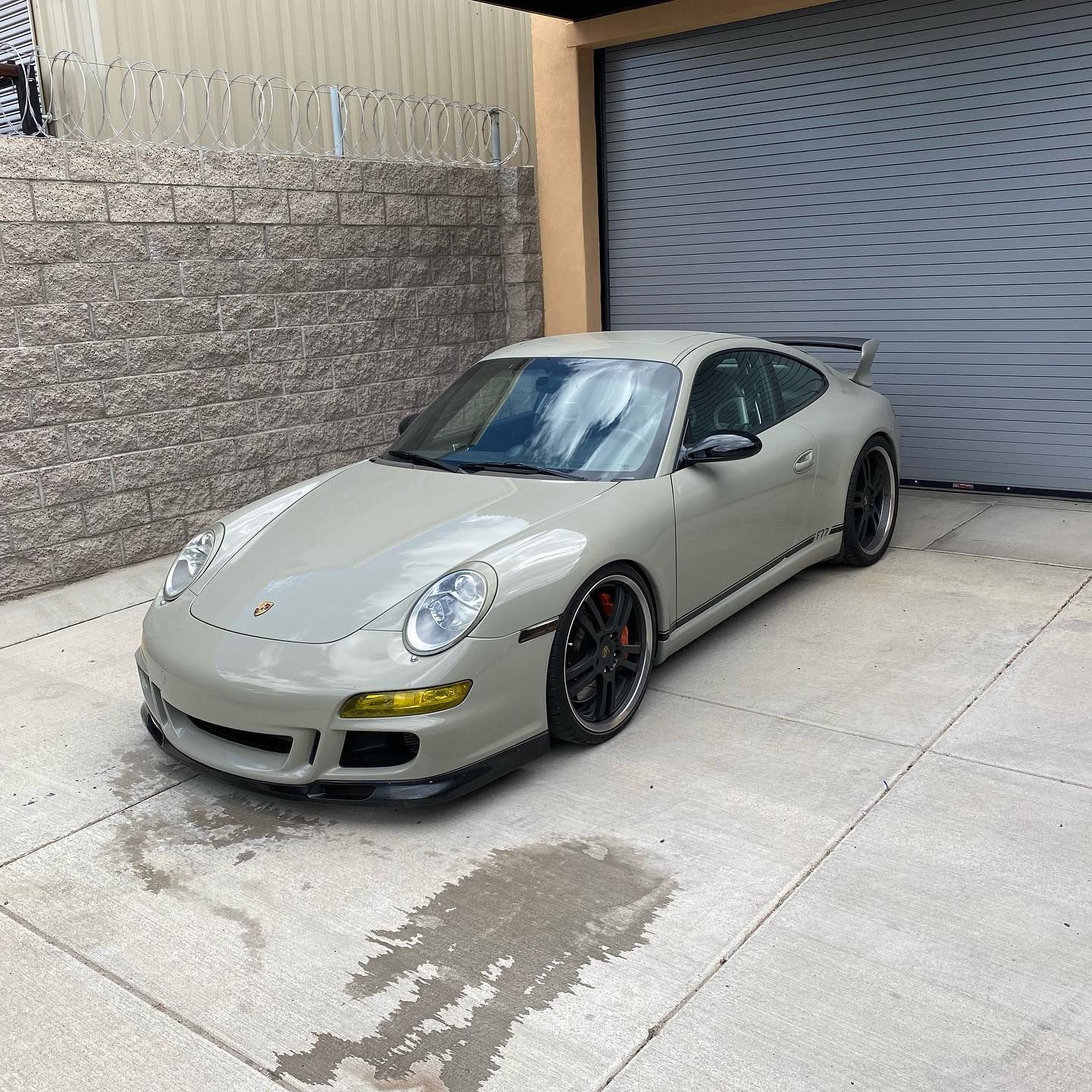 A porsche 911 is parked in front of a garage door.