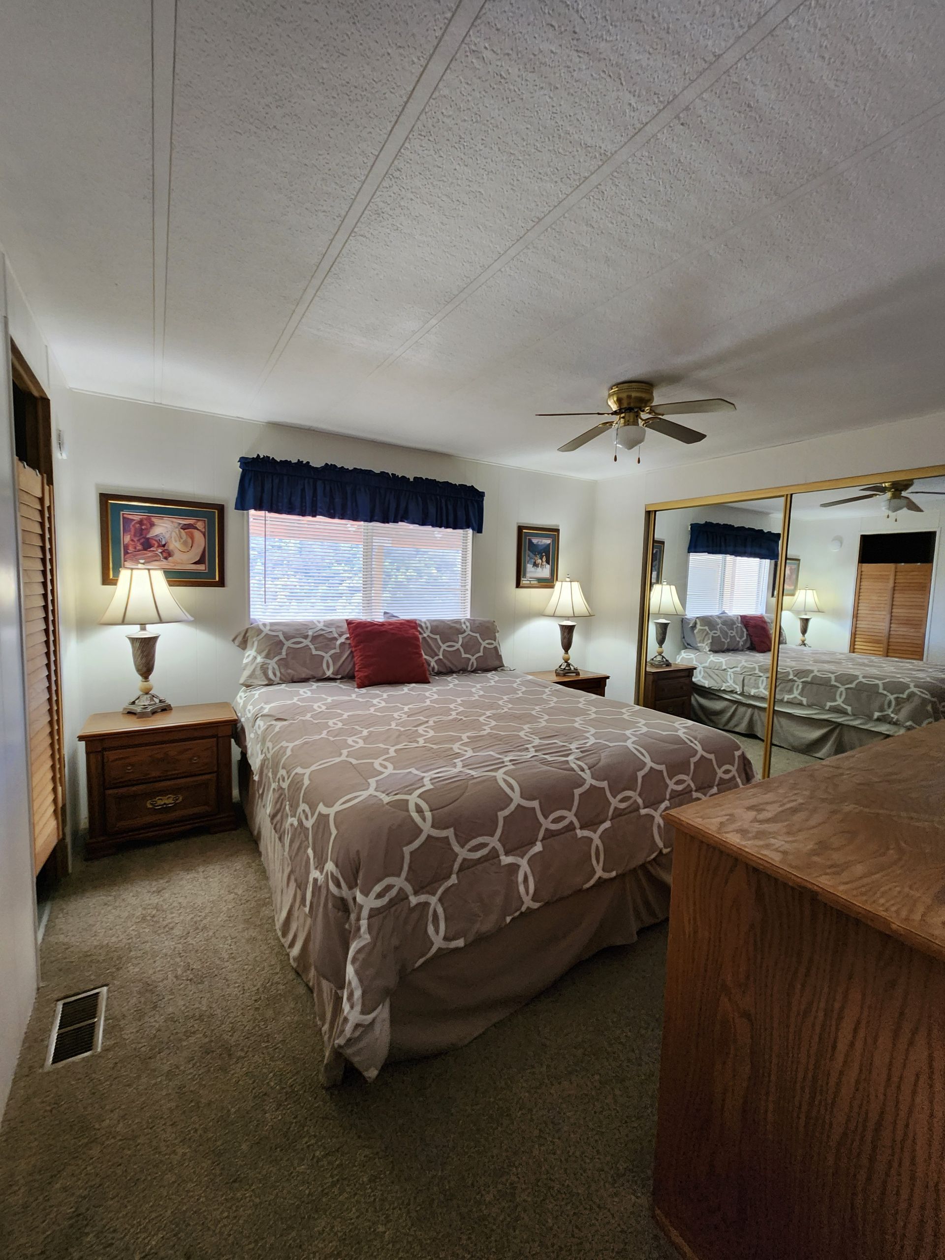 A bedroom with a large bed and a mirror