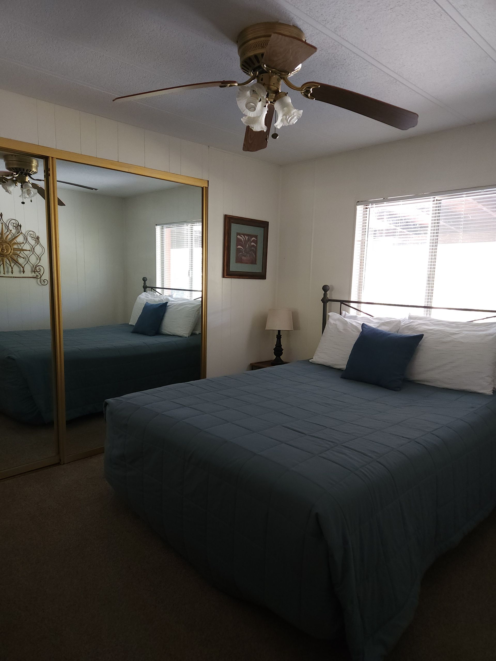 A bedroom with two beds and a ceiling fan