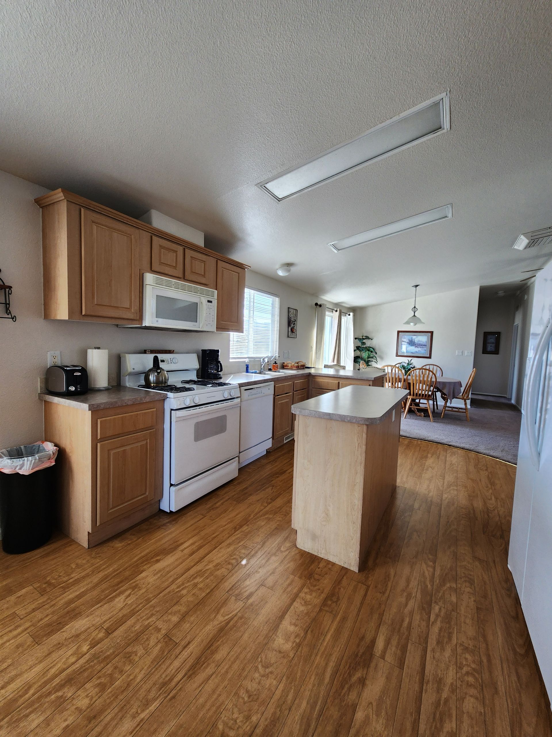 A kitchen with wooden cabinets and a large island in the middle