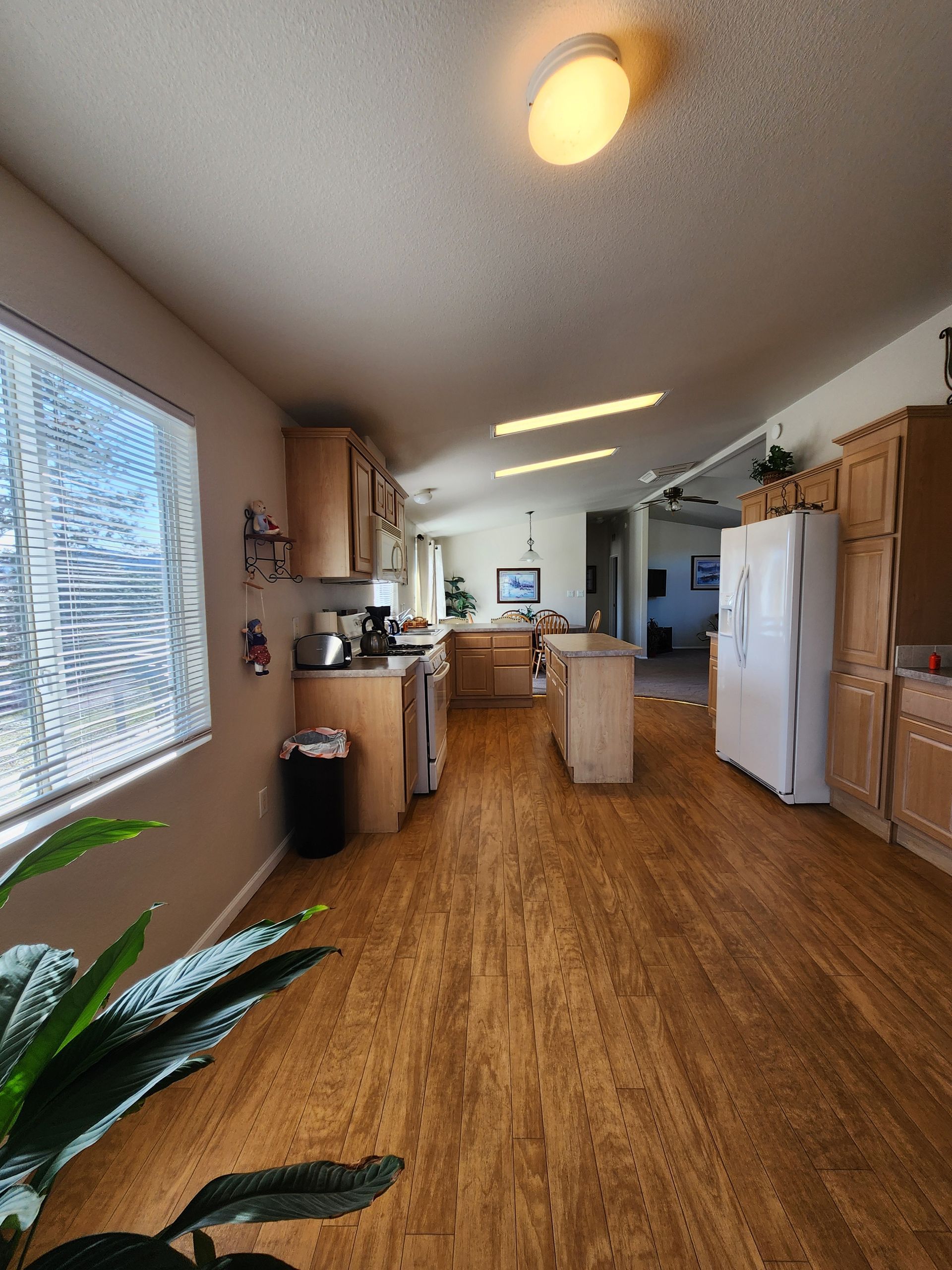 A kitchen with hardwood floors and a large window