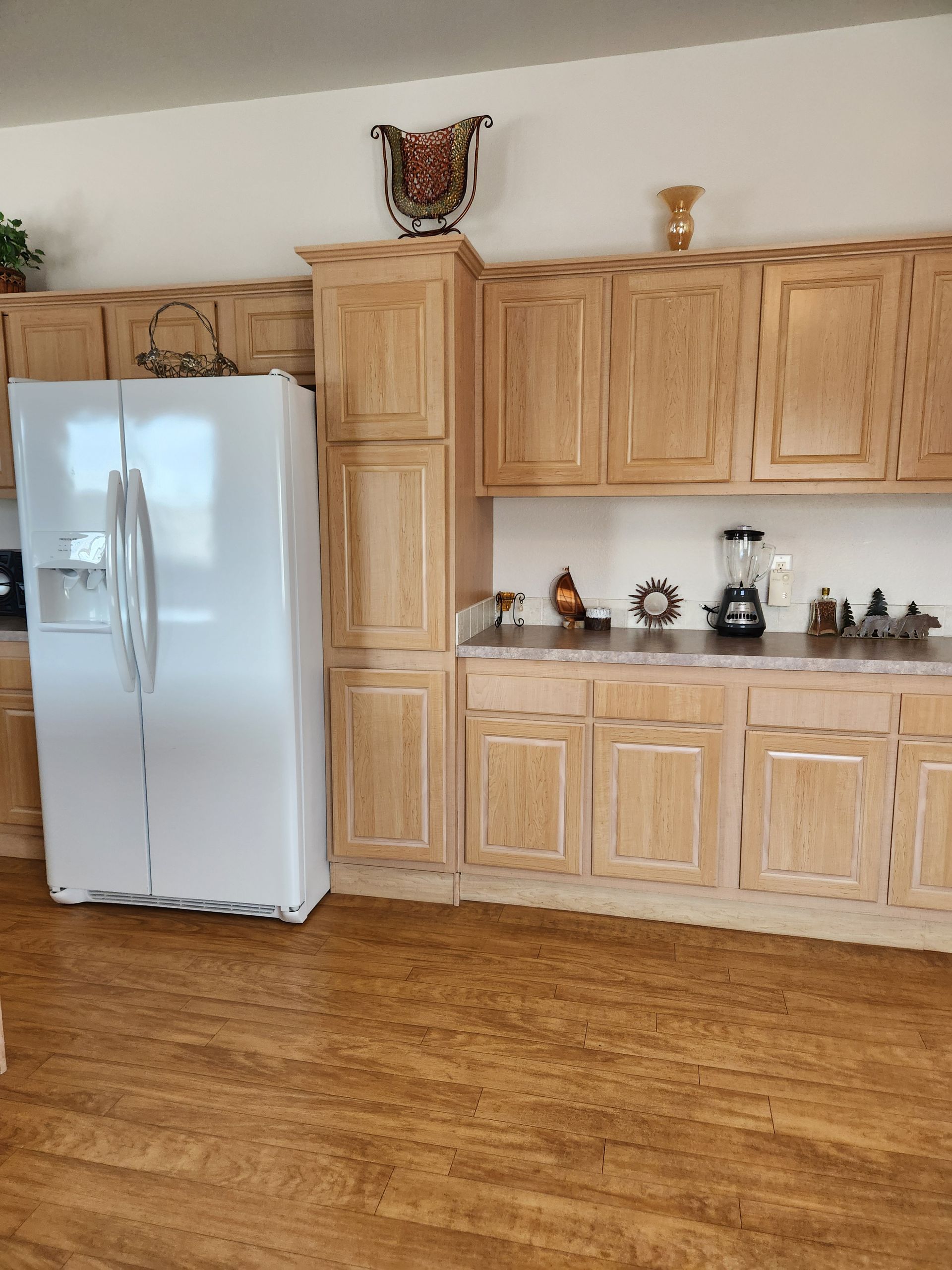 A kitchen with wooden cabinets and a white refrigerator