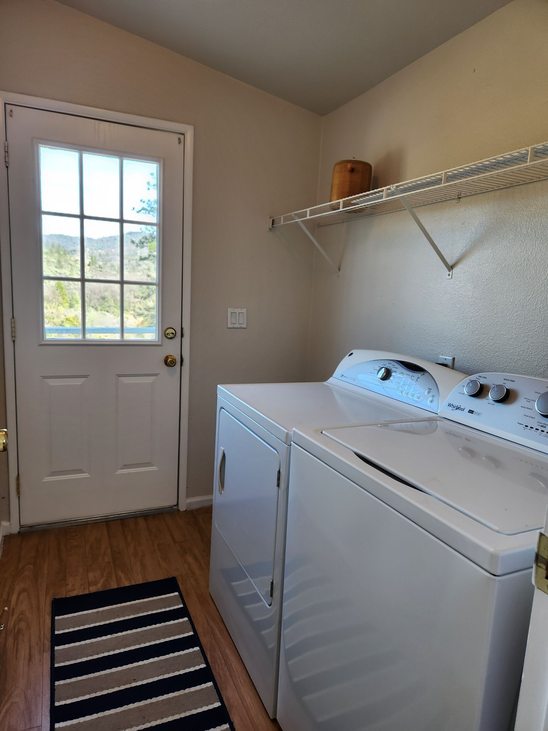 A laundry room with a washer and dryer and a door
