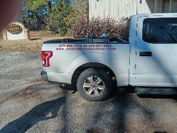 A white truck is parked in front of a building