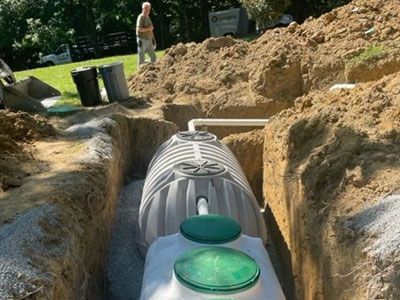 A septic tank is being installed in a trench.