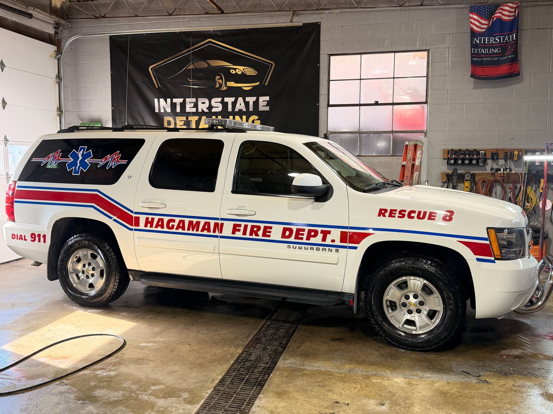 White Magamon Fire Dept. rescue SUV parked in a garage, with red and blue emergency markings