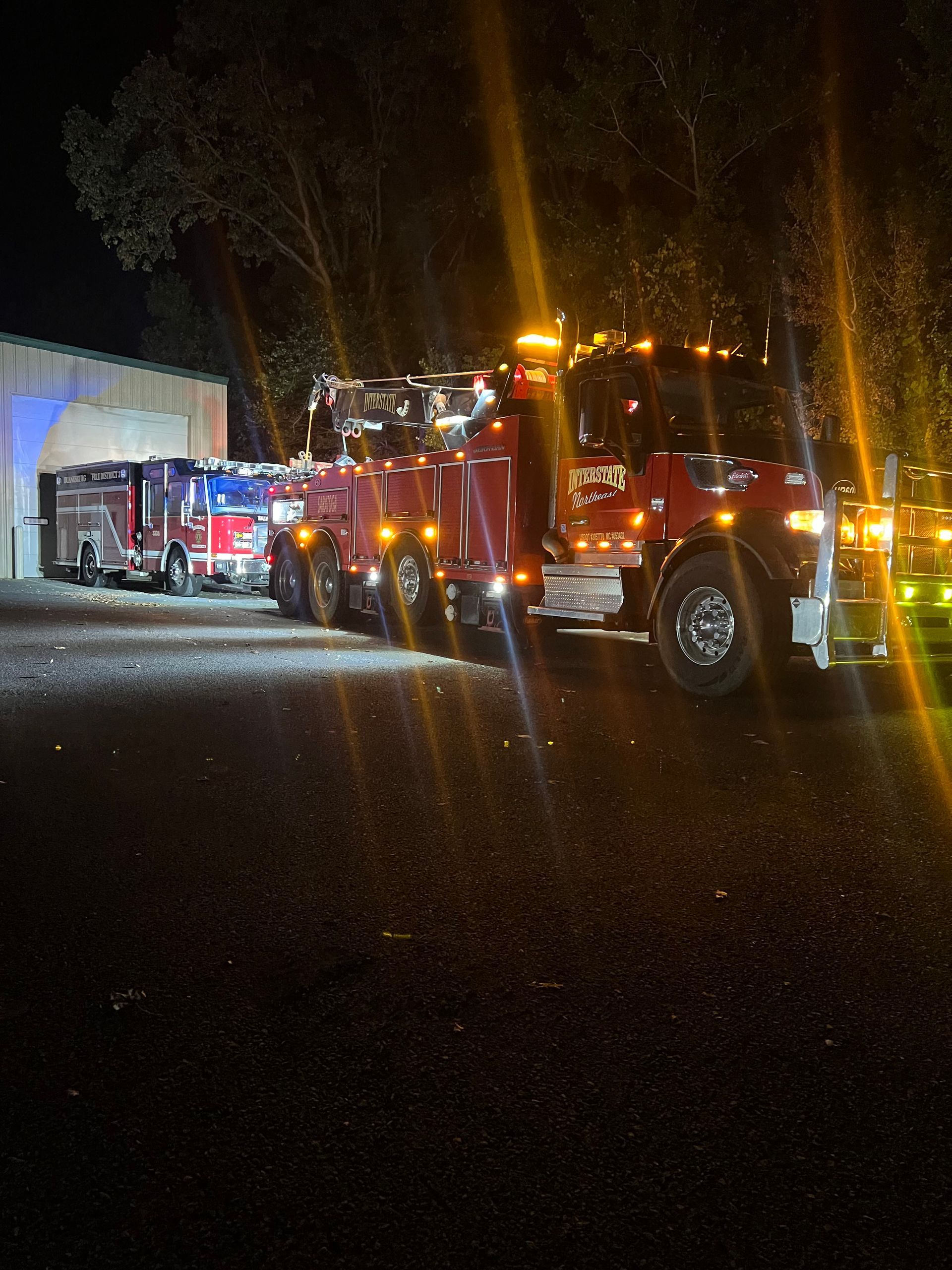 Fire trucks with flashing lights parked outside a building at night