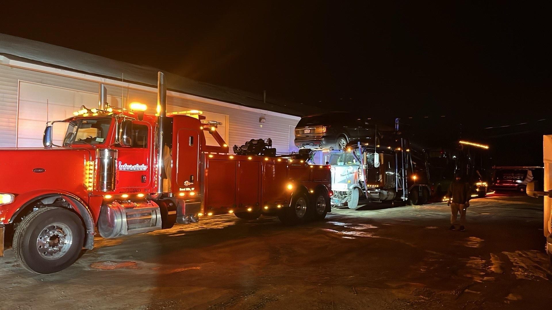 Red fire truck and emergency vehicles at night outside a building, with responders on scene.