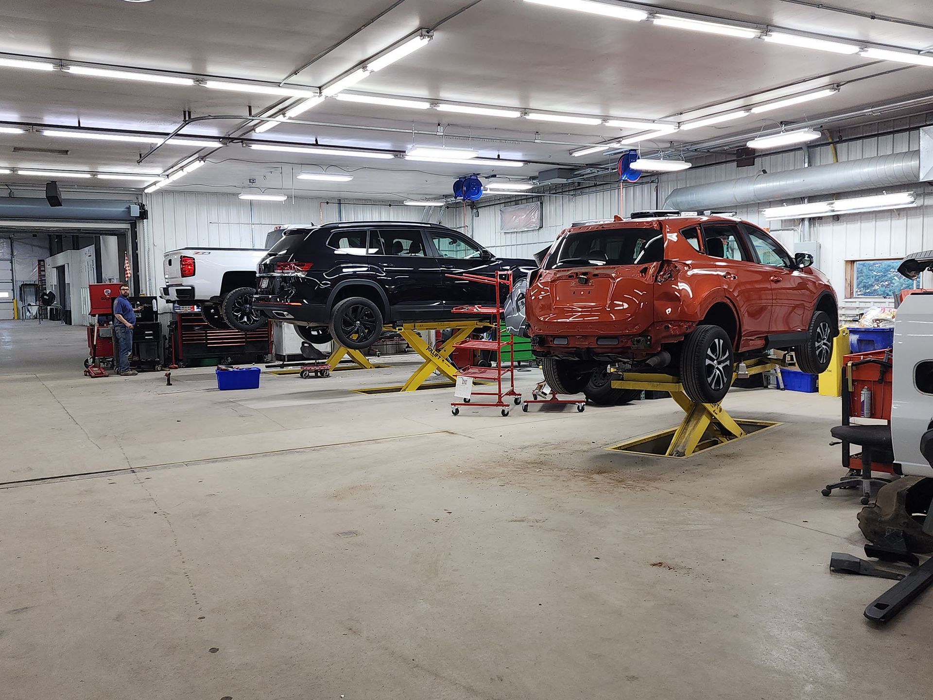 A car is sitting on a lift in a garage.