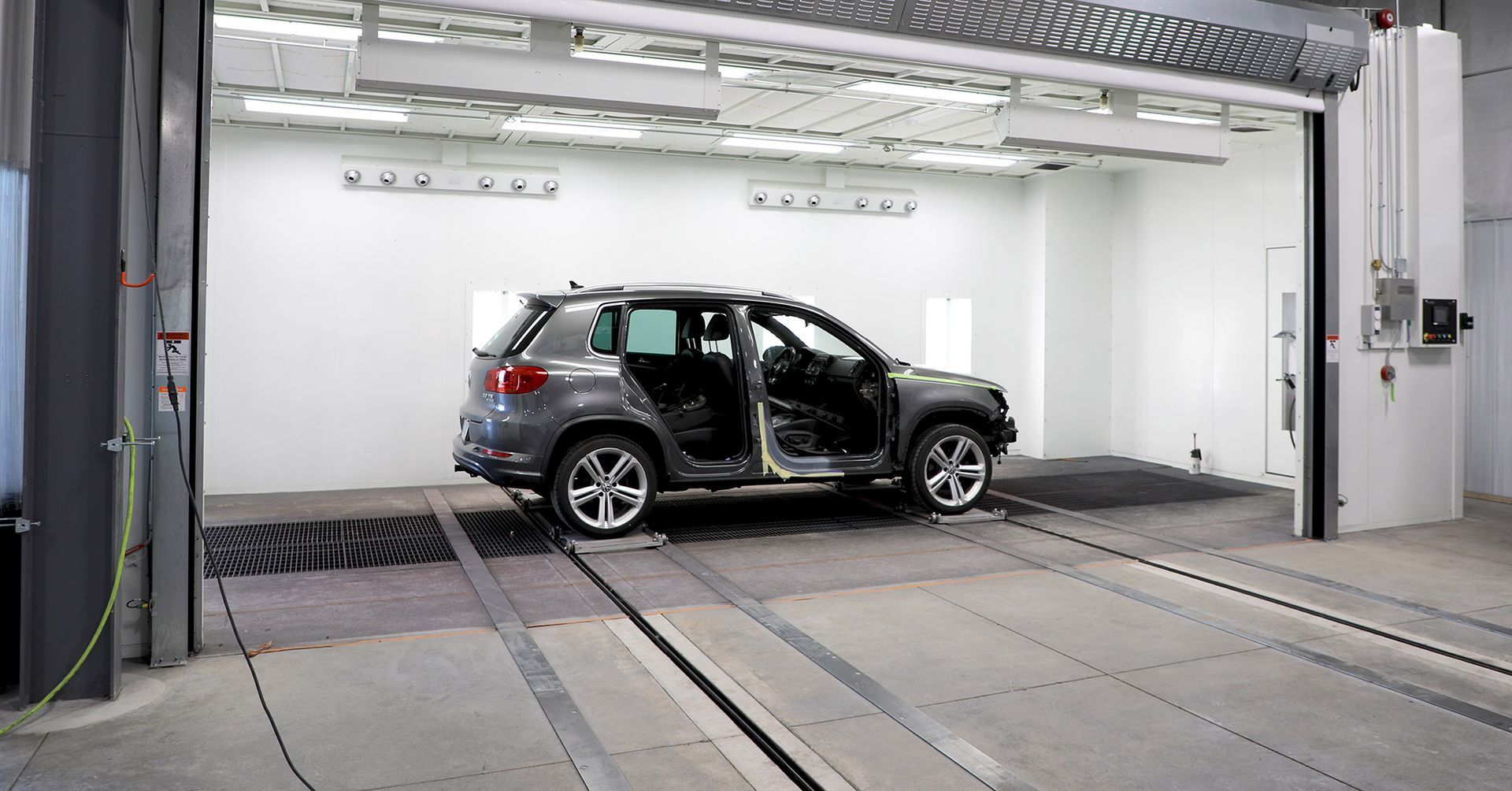 A car is parked in a garage with its doors open.