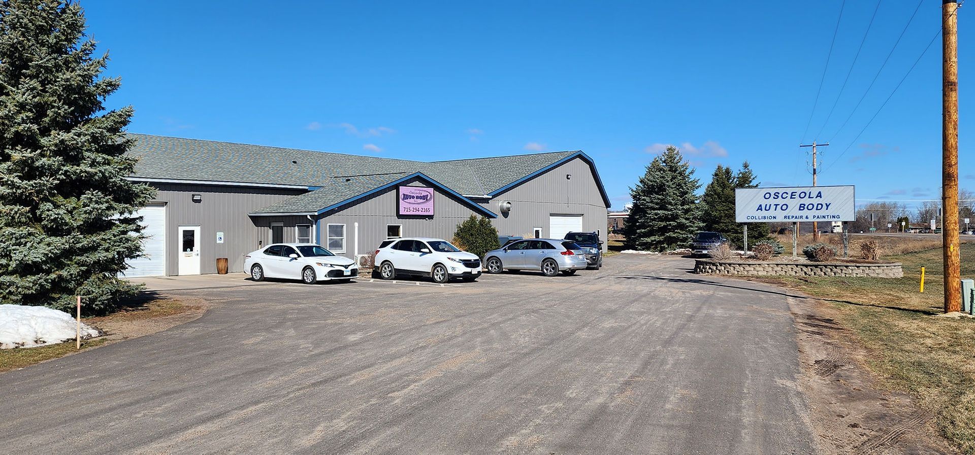 A row of cars are parked in front of a building.