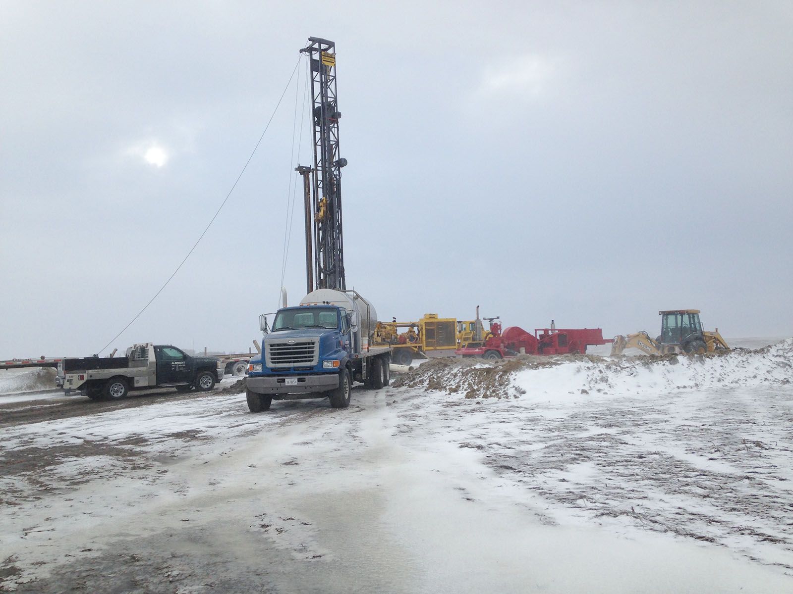 Drilling rig and truck on a snowy construction site