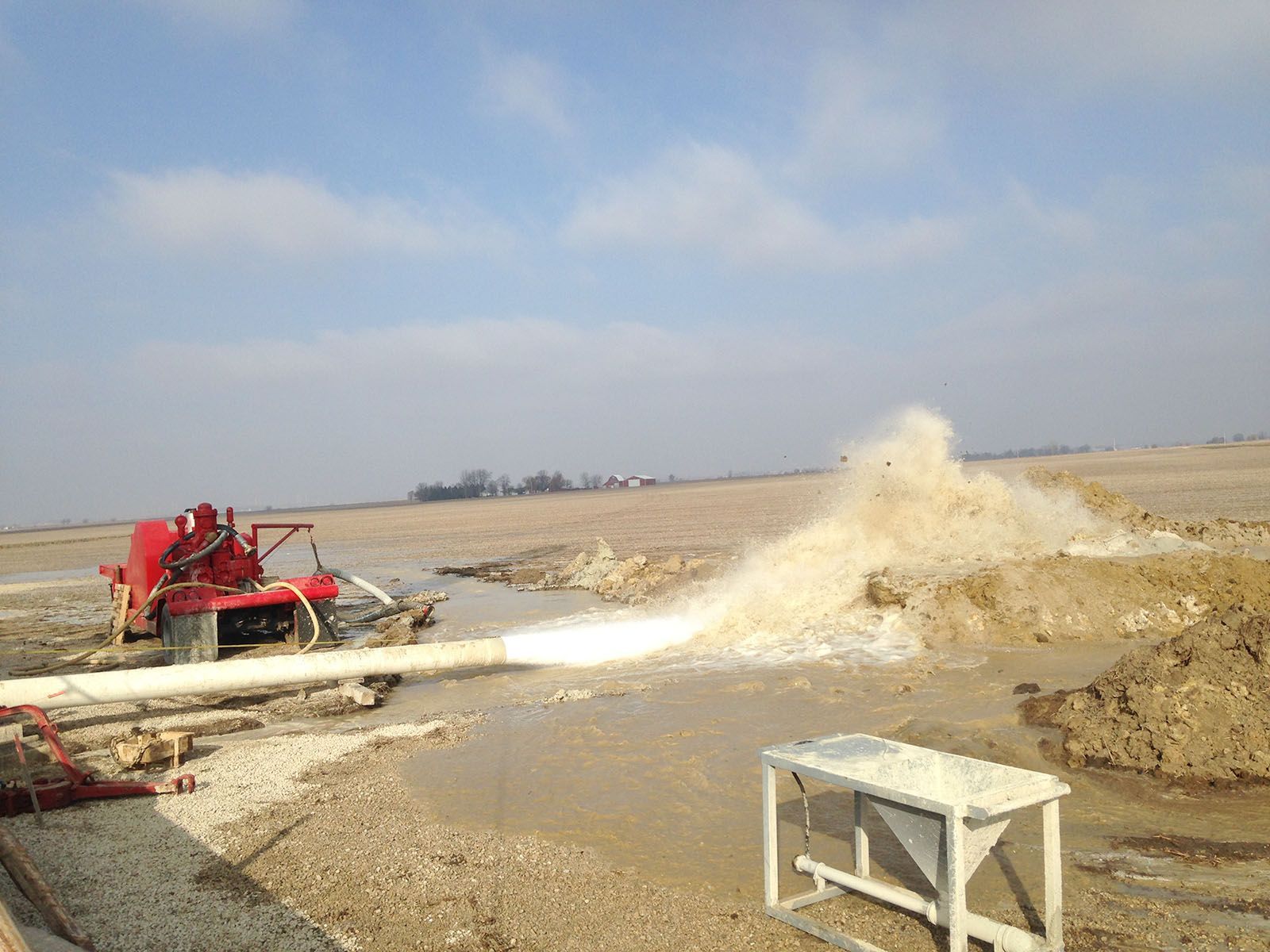 A rig pumping water onto a muddy construction site