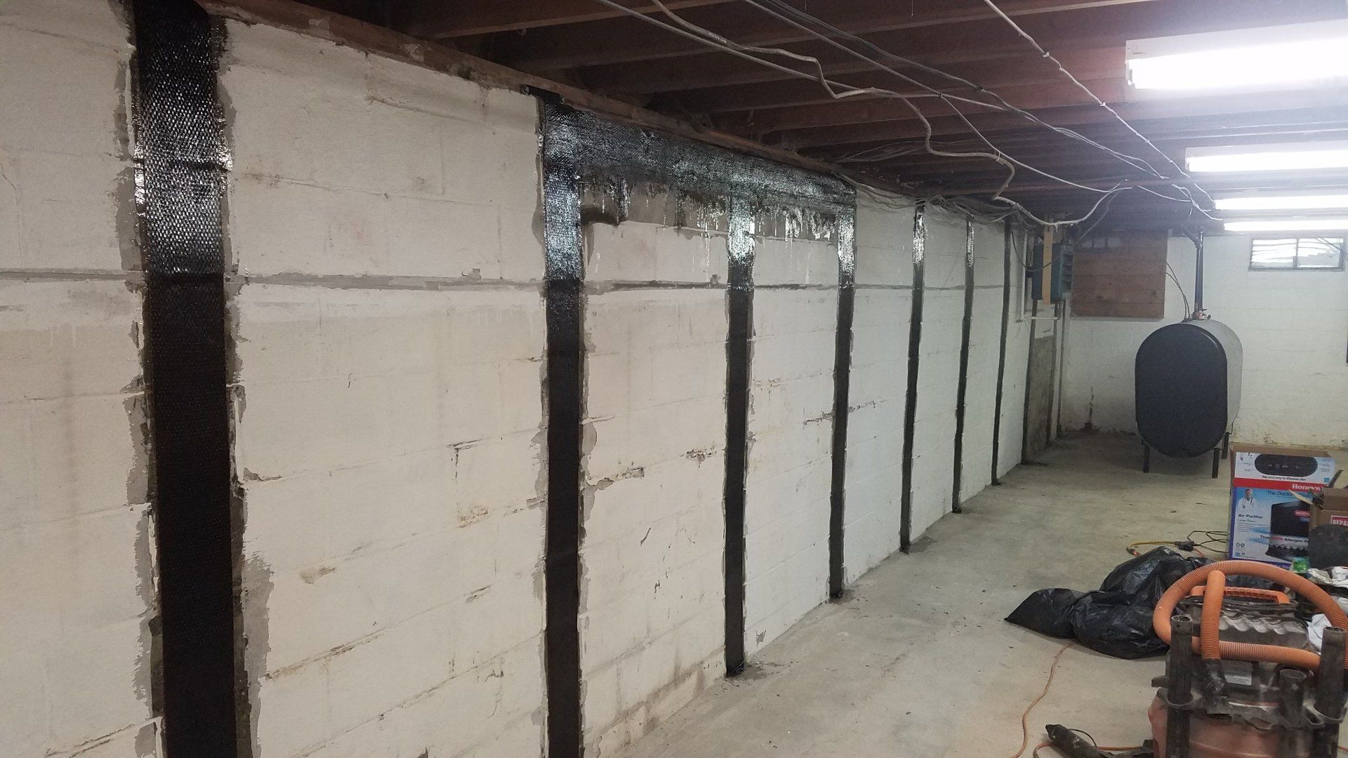 A basement with a lot of concrete walls and a ladder.