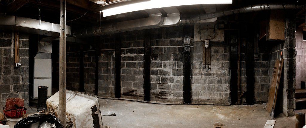 A dark basement with a brick wall and a light on the ceiling.