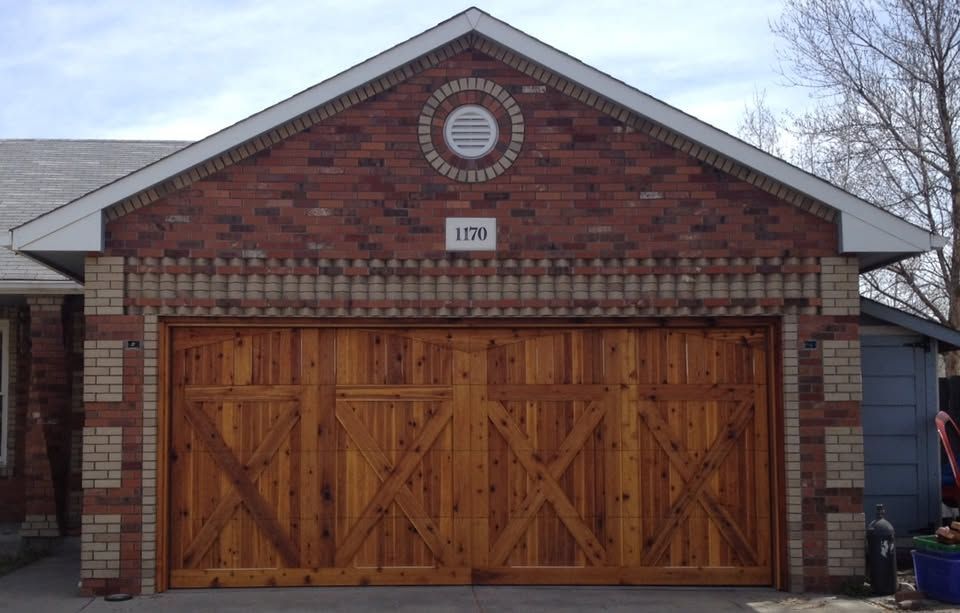 Brick house garage with double wooden doors and a circular decorative window above.