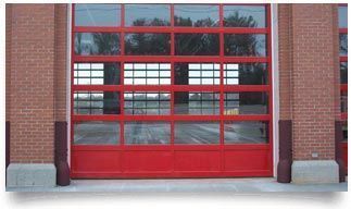 Red garage-style glass door on a brick building facade