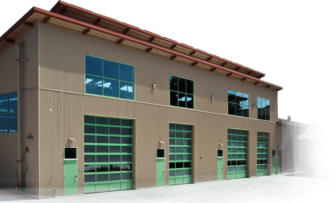 Modern industrial warehouse with green garage doors and blue windows under a sloped roof