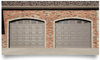 Two beige garage doors set in a brick building facade