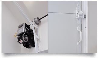 Black wall-mounted garage door opener with rail and side pull cord on white ceiling.