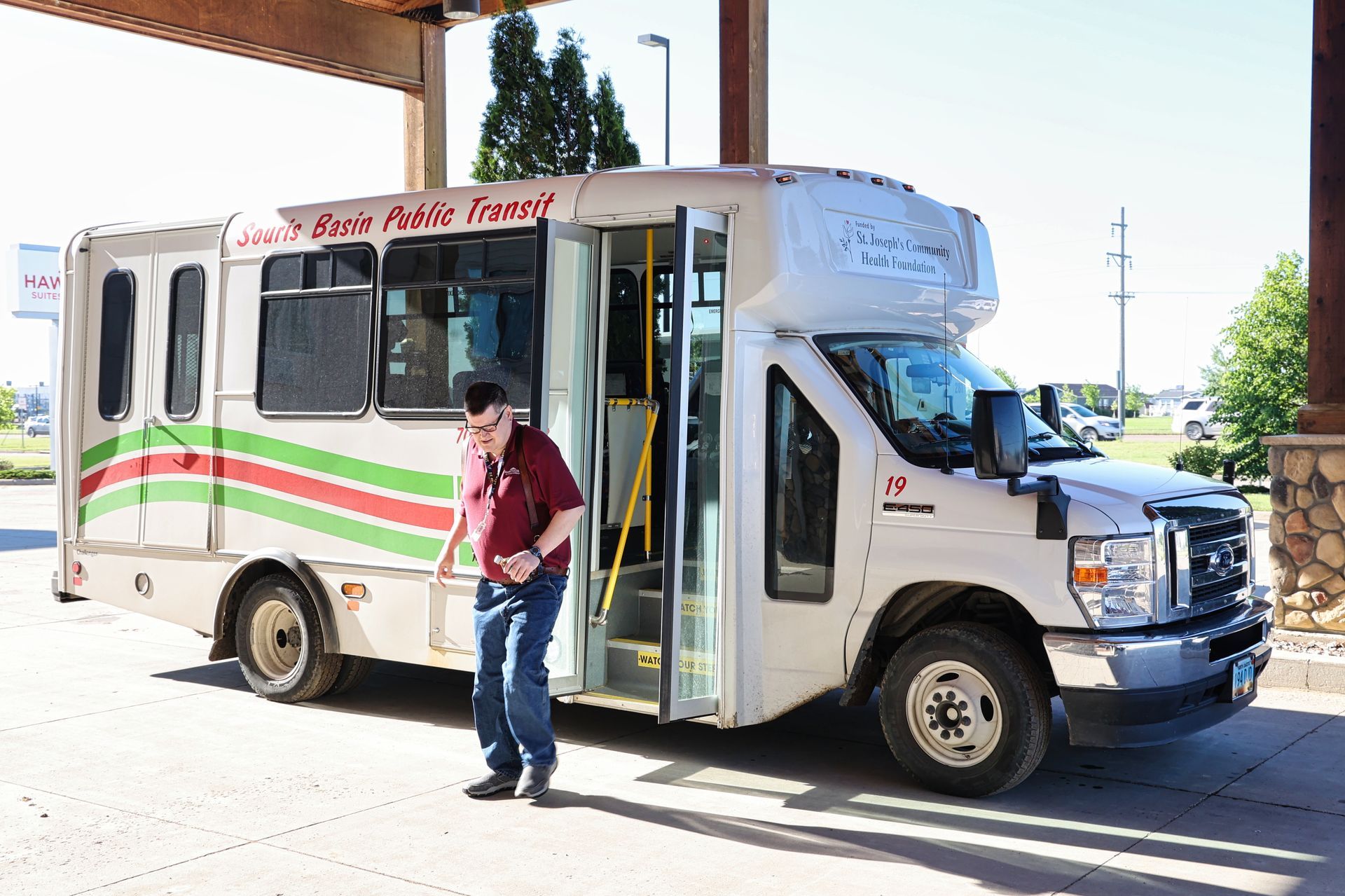 A man is getting on a bus with the doors open.