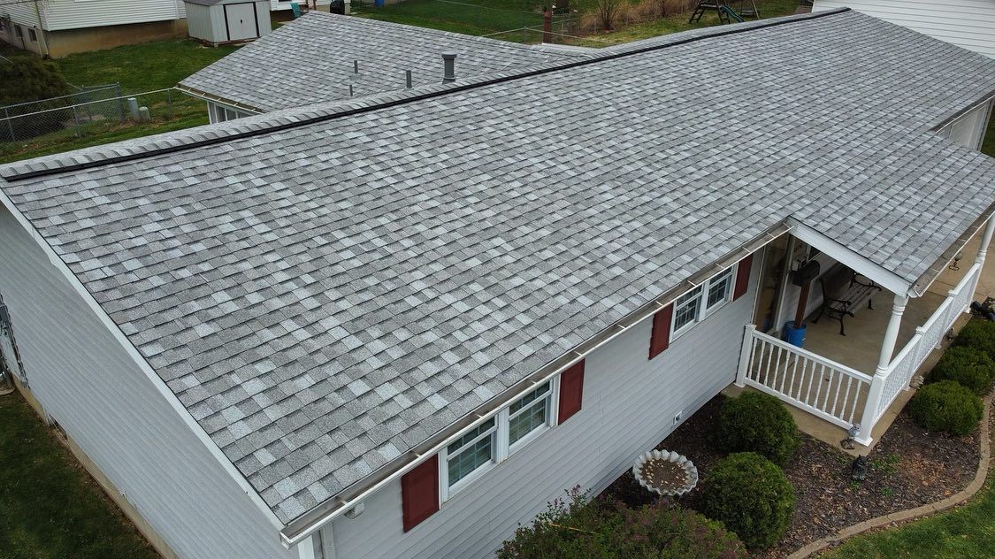 Gray asphalt shingle roof on a single-story house with red shutters and a porch.