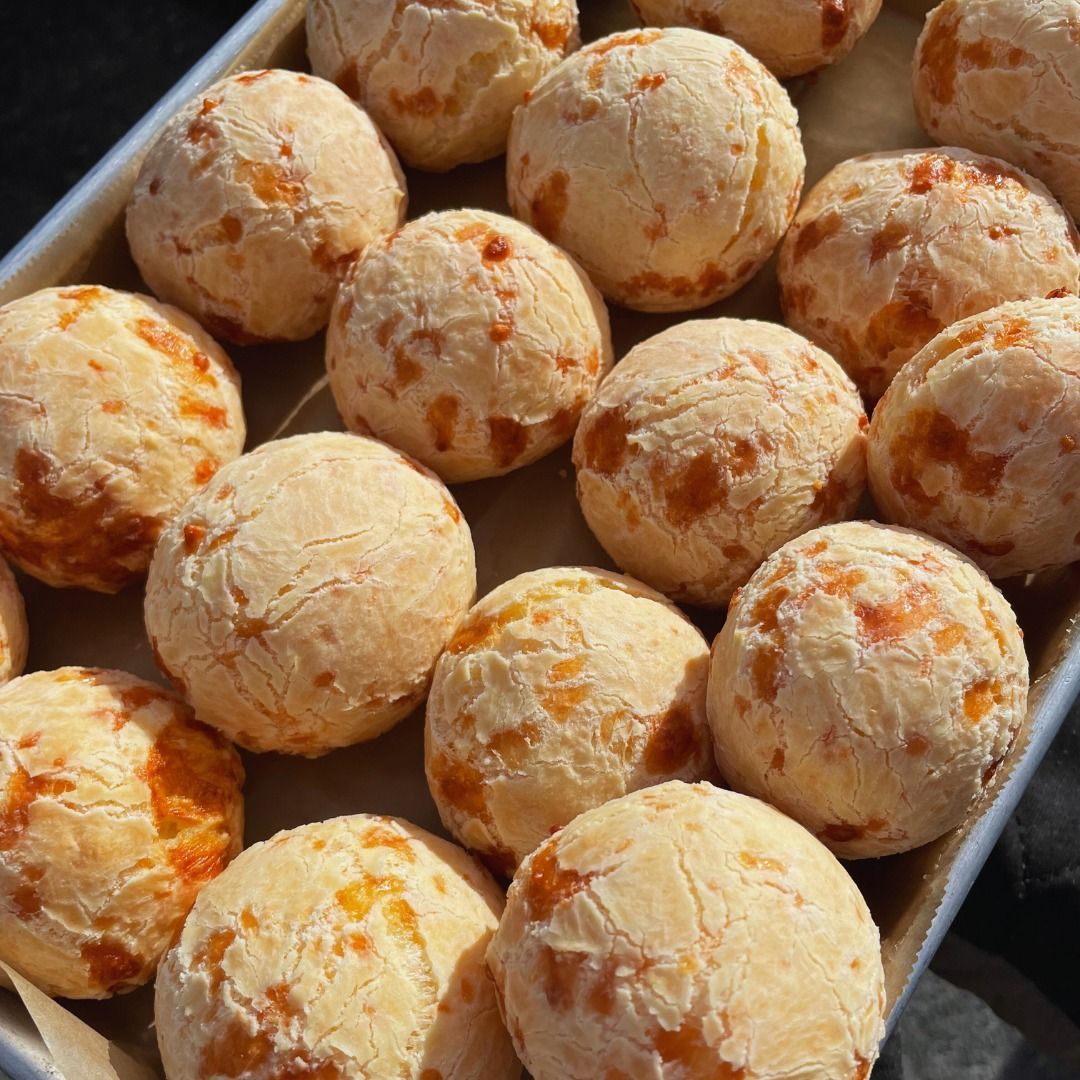 Tray of round golden cheese bread rolls with a crispy, browned crust