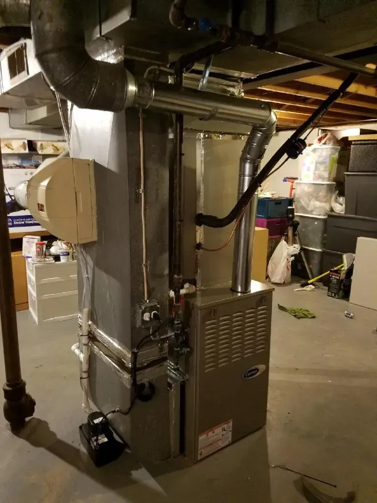 Furnace unit in a basement, with ductwork and a humidifier attached.