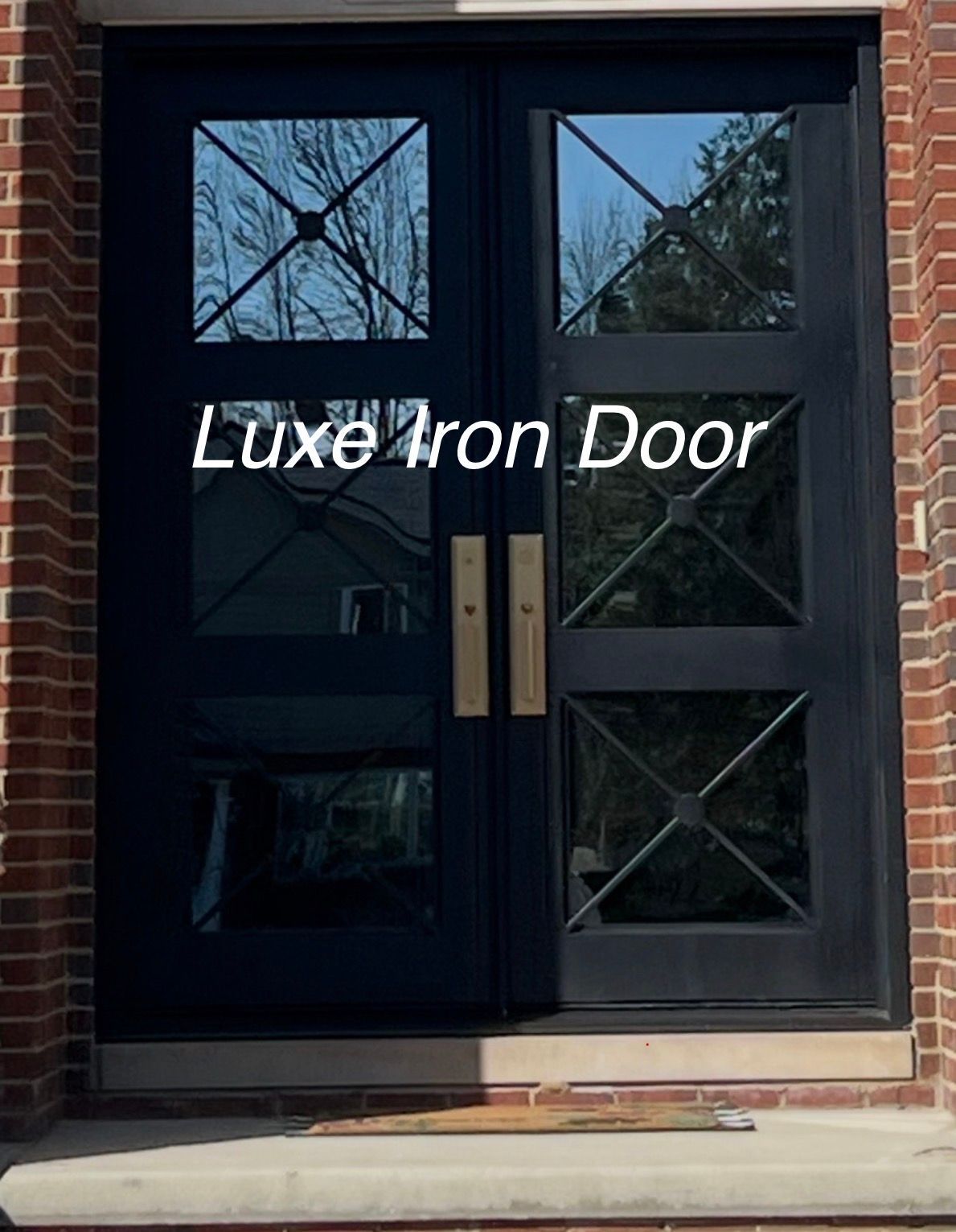 A black double iron door featuring rectangular glass panels with a decorative cross-hatch design, set in a brick frame.