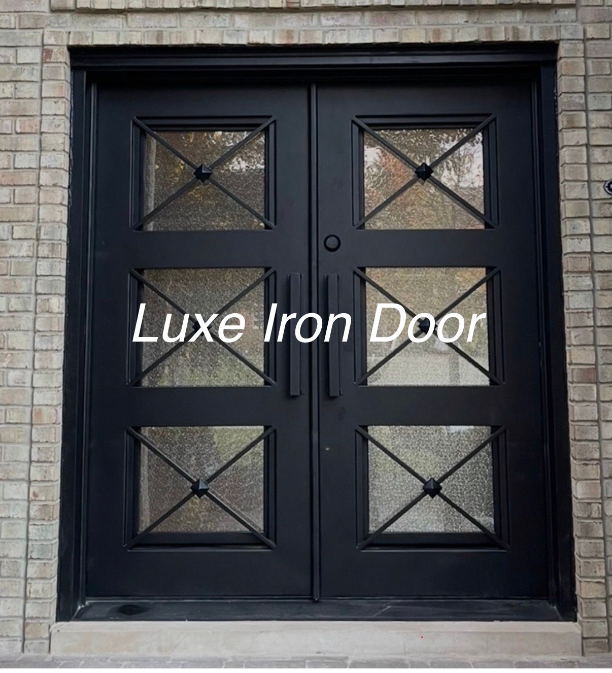 A black double-door iron entry door with three glass panes per door, each featuring an 