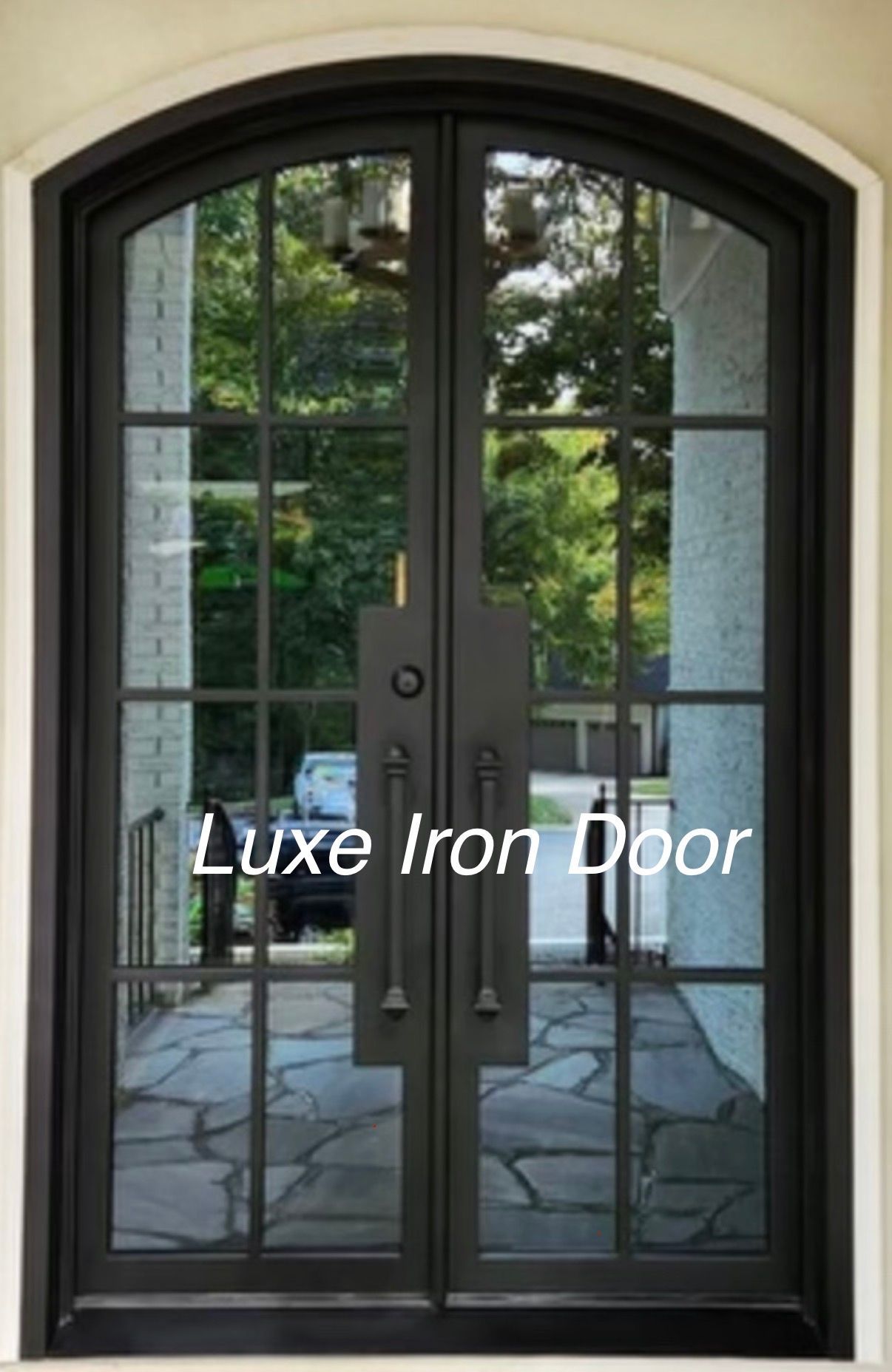 Black arched iron double door with glass panes and sidelights, opening to a patio.