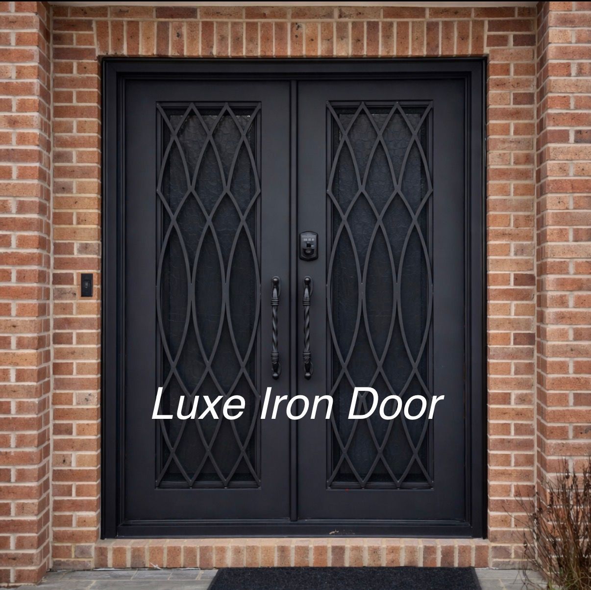 Black iron double front door with decorative glass panels set in a red brick wall.