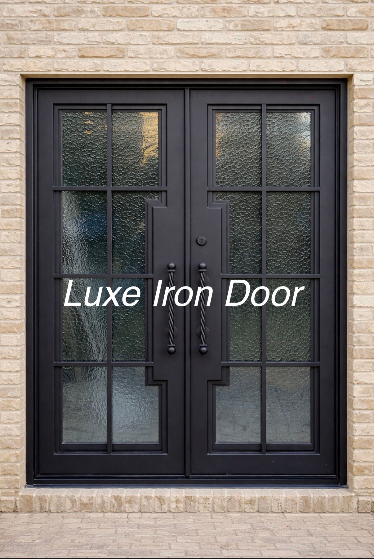 Black double iron door with frosted glass panels in a tan stone wall