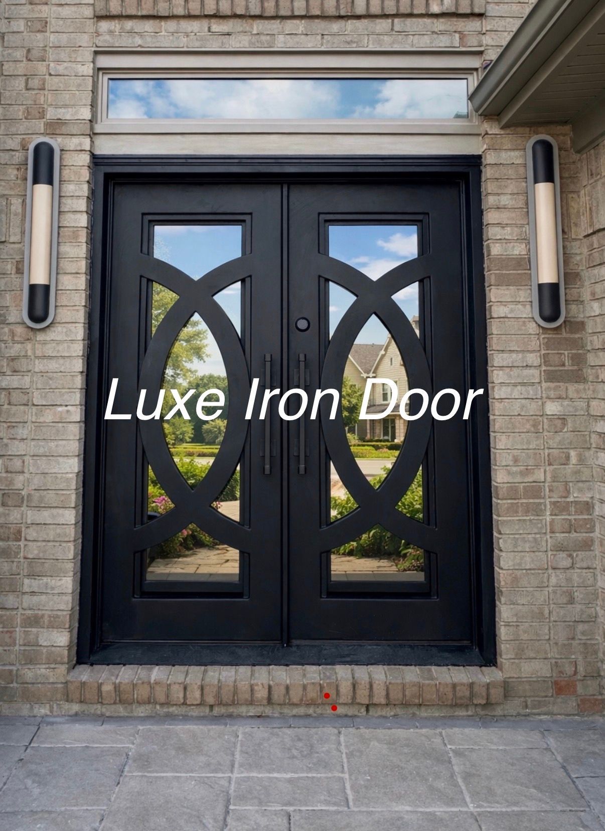 Black iron double front door with geometric glass panels set in a brick exterior.