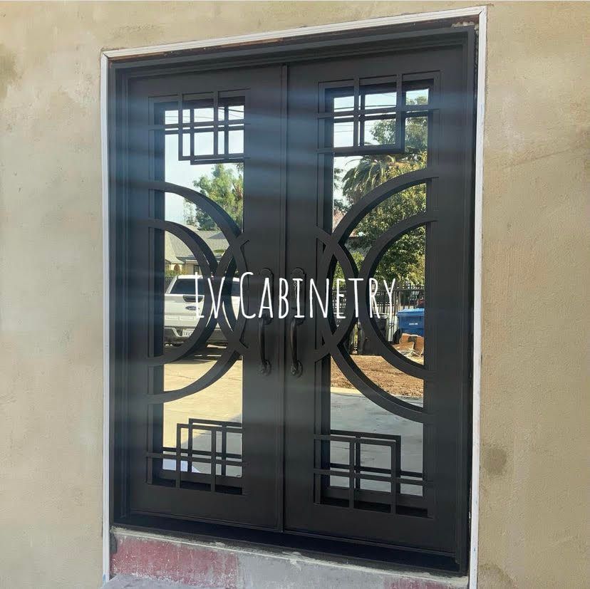 A wrought iron door with a reflection of trees in it