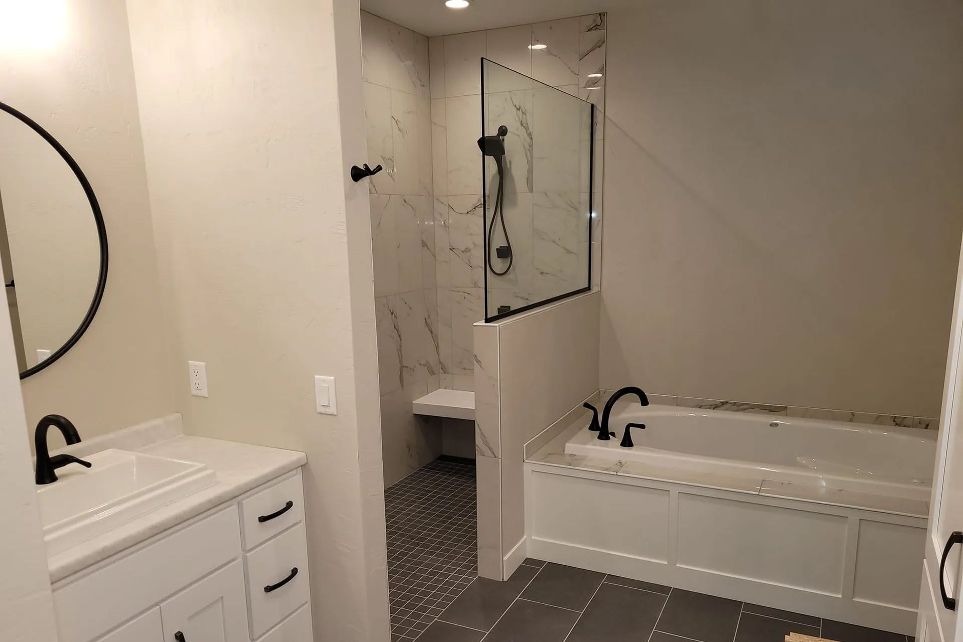 a bathroom with a tub, sink, mirror and shower
